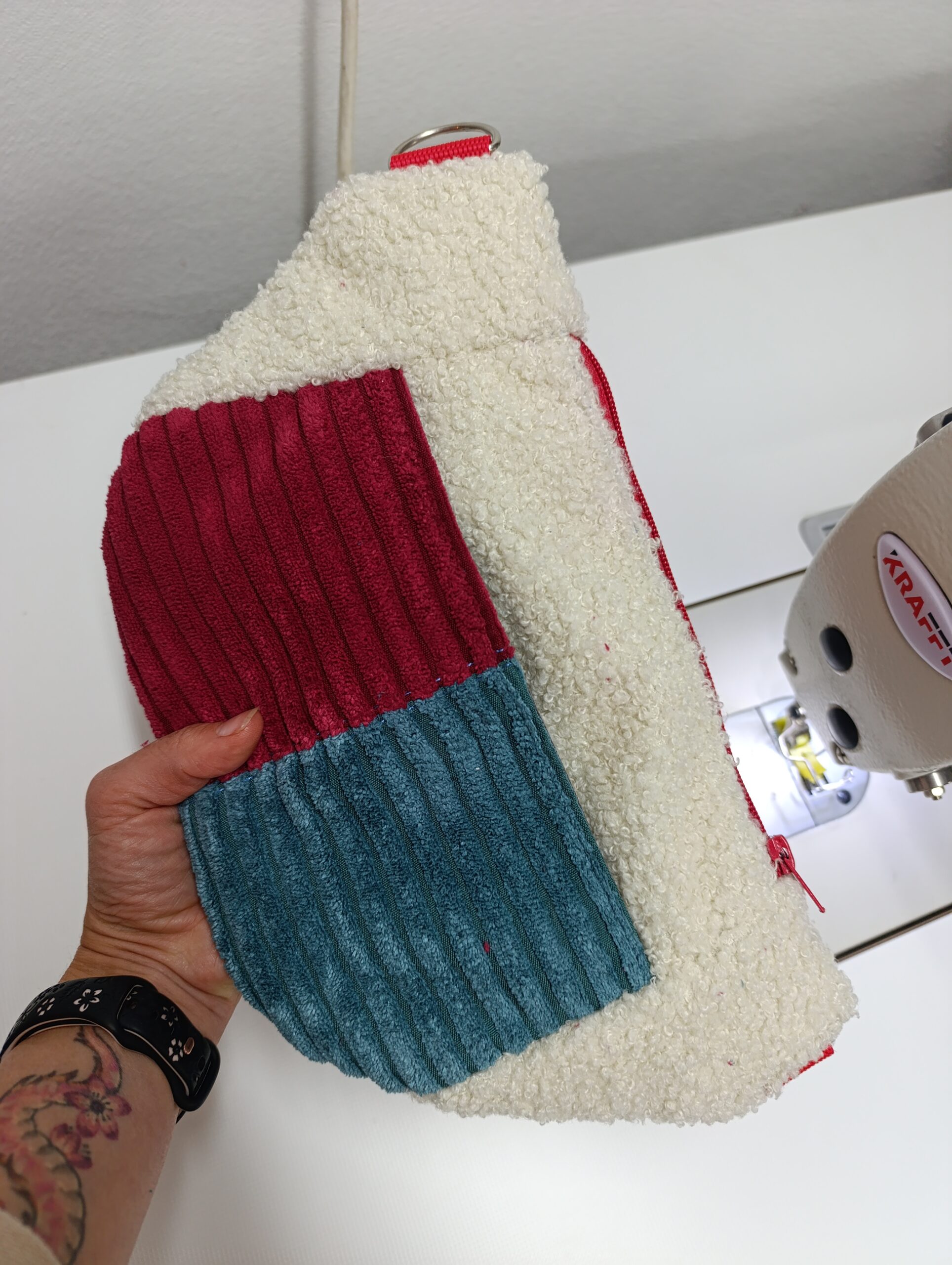 Kremowa puszysta nerka handmade z kieszenią z prążkowanego sztruksu w kolorze bordo i morskim turkusie.